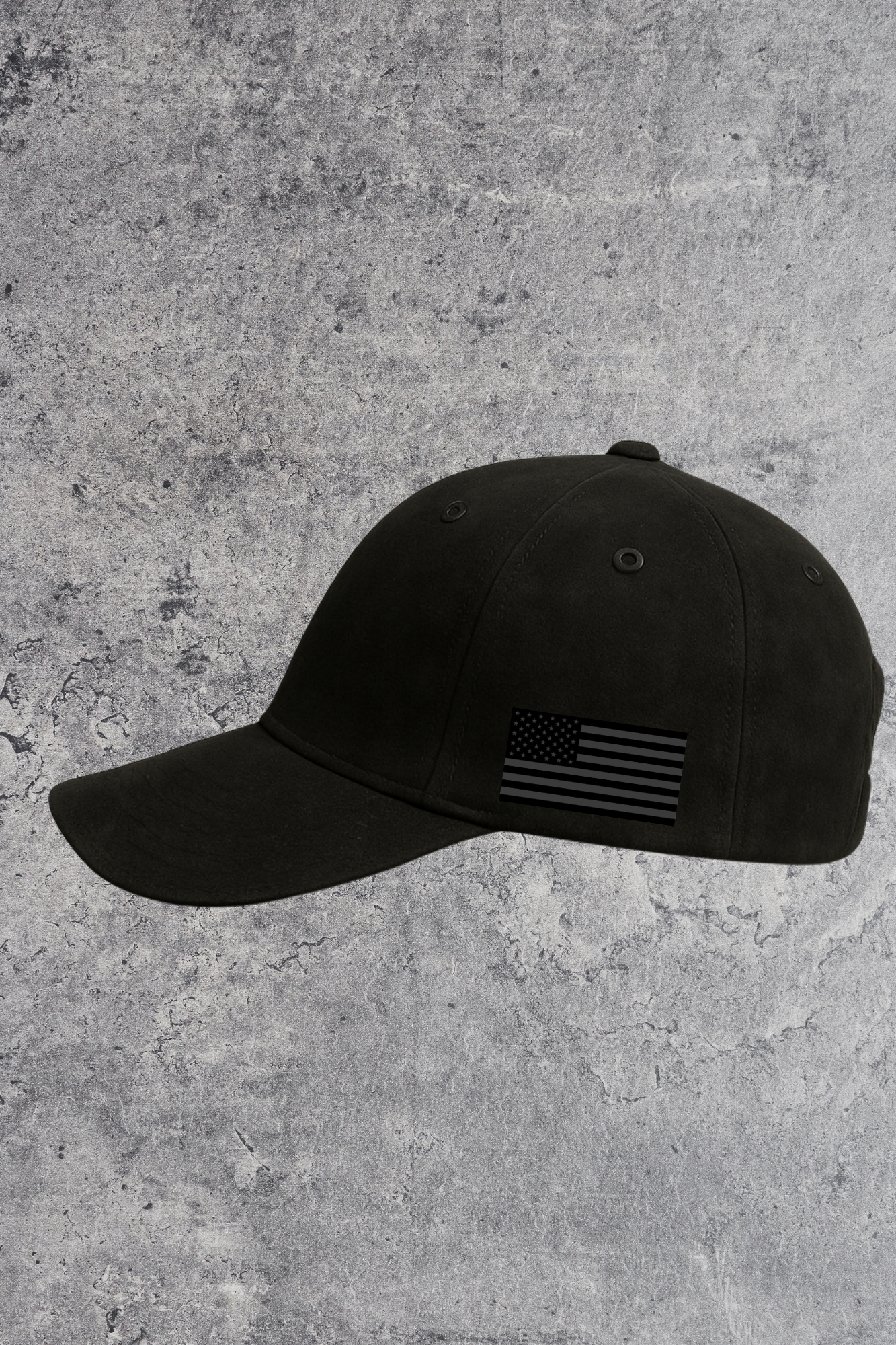 Black cap with American flag patch on a gray concrete background